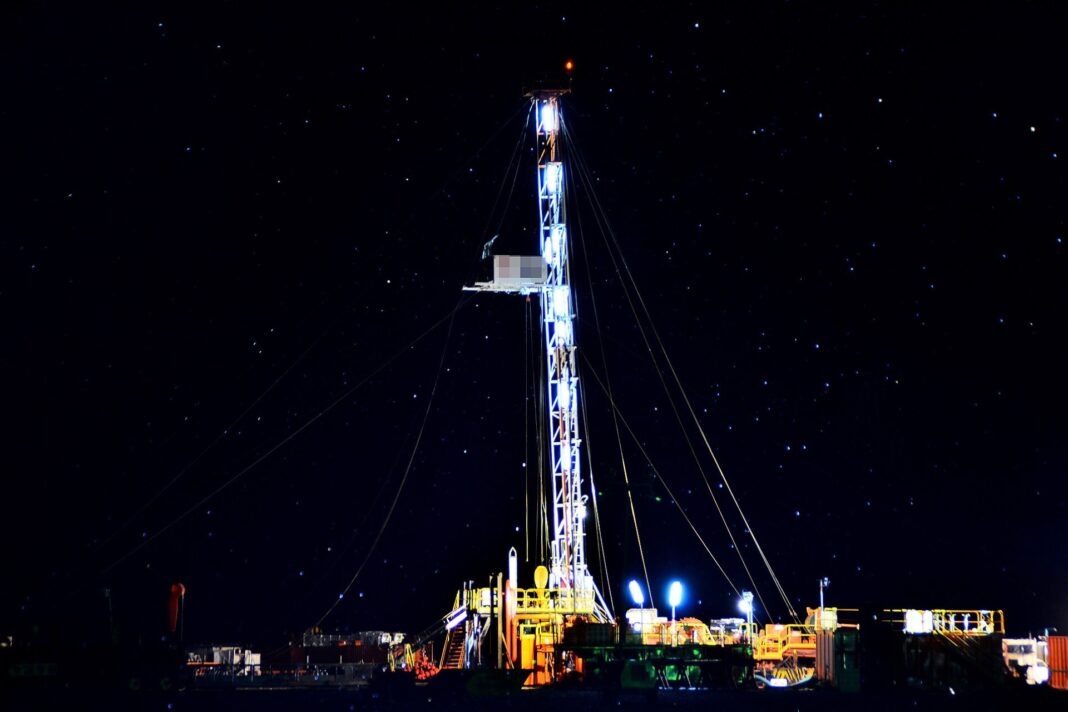 Equipo de perforación iluminado de noche en el yacimiento Vaca Muerta